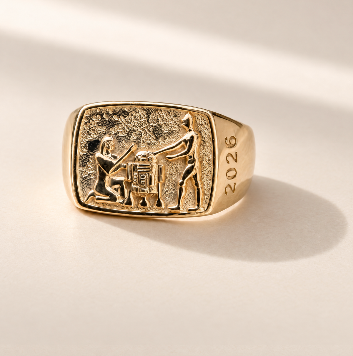 Lucasfilm 14kt gold signet ring with an embossed relief of Pharaoh, R2D2 and C-3PO and the year '2026' on the band, 